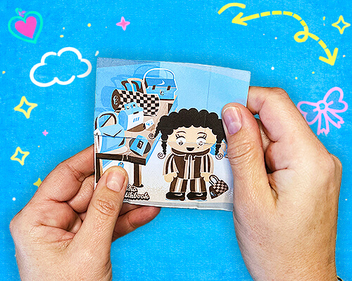 Hands holding an illustrated never-ending card featuring colorful characters and playful scenes.