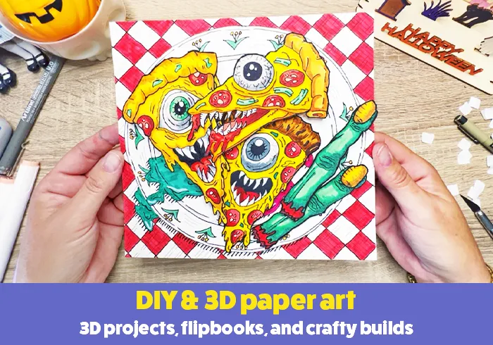 Hands holding a colorful illustrated 3D paper art piece on a craft table.