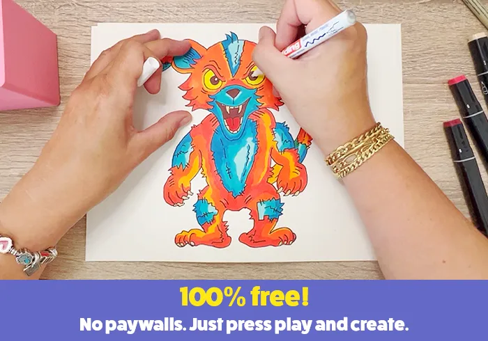 Hands drawing a colorful monster illustration with markers on paper.